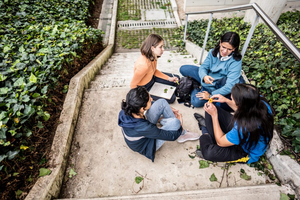 Student friends talking on the stairs outdoors